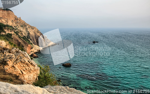 Image of Sea with rocky beach at sunset