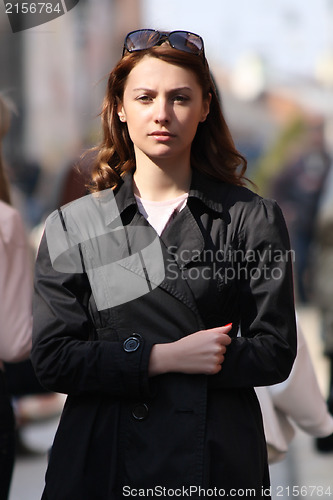 Image of Young woman among human rush in the city