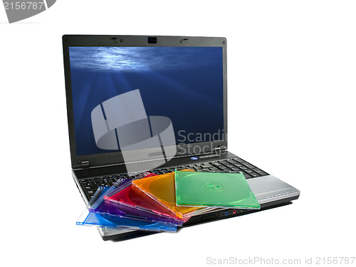 Image of Colored cd`s on a laptop isolated. Nice rays of light on desktop