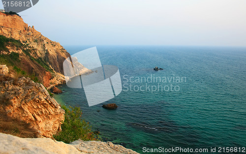 Image of Sea with rocky beach at sunset