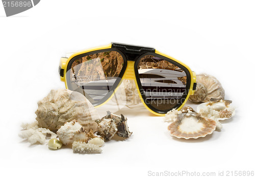Image of Yellow diving mask with sea shells and sea yacht reflection