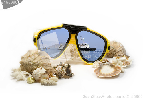 Image of Yellow diving mask with sea shells and sea reflection