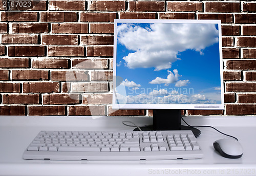 Image of PC with black desktop and brick wall background and sky desktop