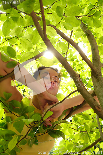 Image of Young beautiful woman outdoors in sunny park