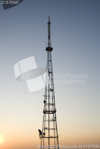 Image of communication tower at sunset with cityscape