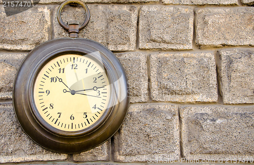 Image of Old street clock on a stone wall