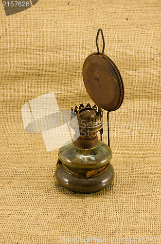 Image of rusty retro paraffin lamp burlap background 