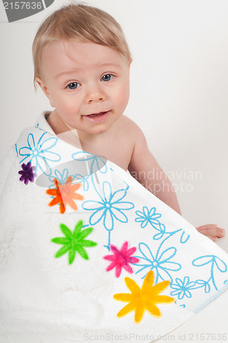 Image of Little boy in white blanket with flowers