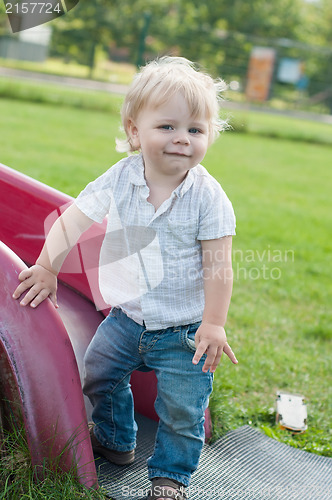 Image of The little boy standing near children's slides