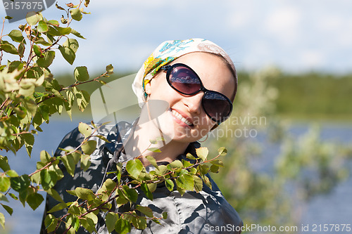 Image of Portrait of a blond girl behind the green bush