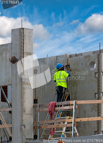 Image of Working in a green jacket at a construction site