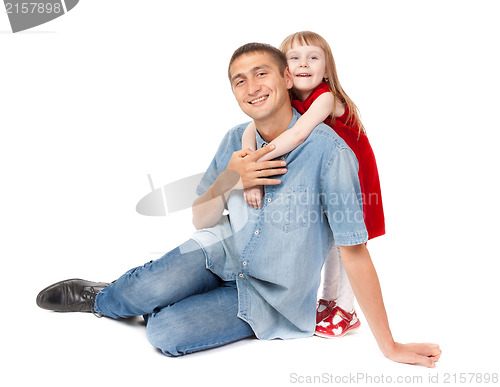 Image of Smiling father and young daughter sitting on the floor