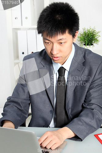 Image of Professional Asian man focusing at his desk