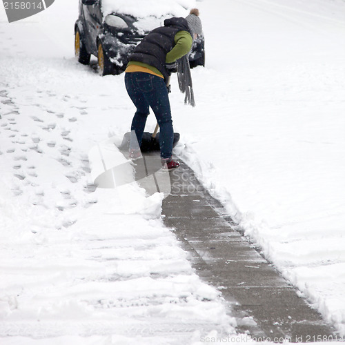 Image of Person clearing snow off a pathway