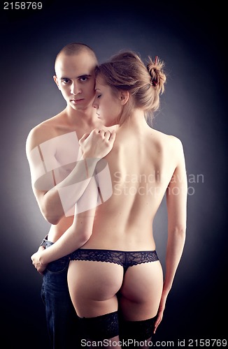 Image of Muscular man and topless girl