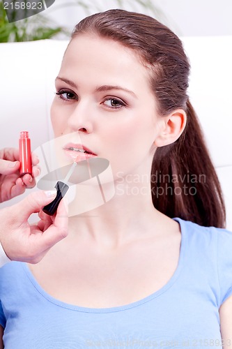 Image of woman applying lipstick on lips natural beauty