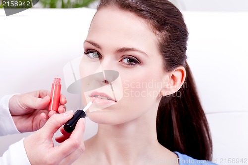 Image of woman applying lipstick on lips natural beauty