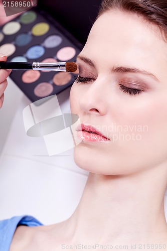 Image of doing the makeup brown eyeshadow on beautiful eyes