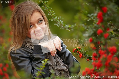 Image of Beautiful girl near a positive snowball bushes.