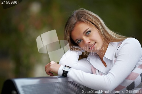 Image of Beautiful girl sitting on the bench