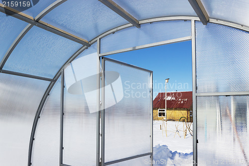 Image of View of a country house inside greenhouse winter