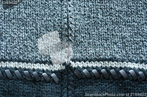 Image of wool knit sweater leather stitch backdrop closeup 