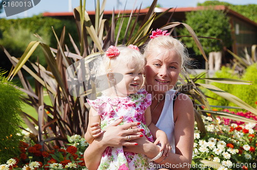 Image of Mum with a small daughter among flowers  in park