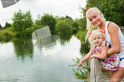 Image of mother and small daughter by the pond at the Zoo