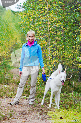 Image of The woman with a dog walk in an autumn wood