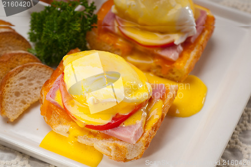 Image of eggs benedict on bread with tomato and ham