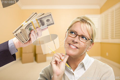 Image of Woman Being Handed Stacks of Money in Empty Room