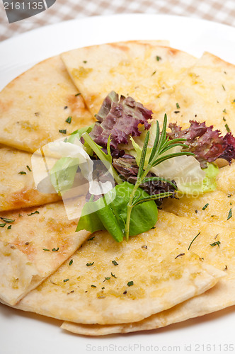 Image of garlic pita bread pizza with salad on top