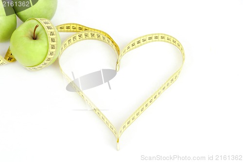 Image of green apple with a measuring tape and heart symbol isolated