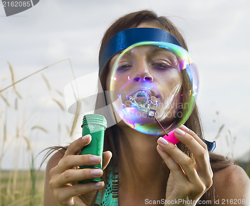 Image of face of woman that blows soap bubbles