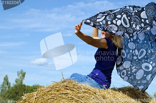 Image of woman happy smile straw bale headscarf scarf wind 