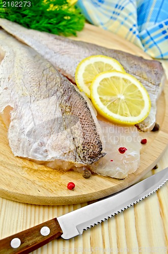 Image of Fillets codfish on a board with a knife