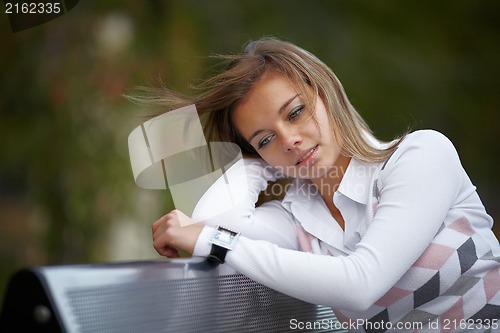 Image of Beautiful girl sitting on the bench