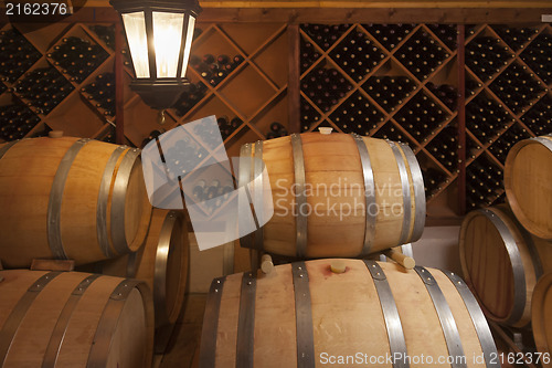 Image of Wine Barrels and Bottles in Cellar