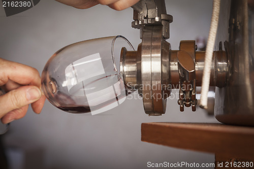 Image of Vintner Pours Taste of Wine from Barrel into Glass