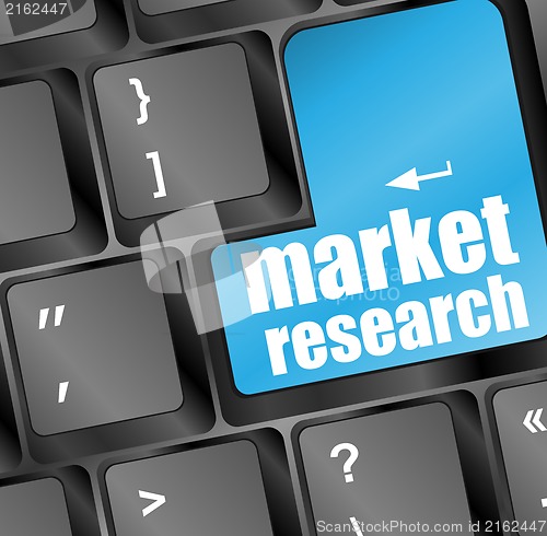 Image of Blue key with market research text on laptop keyboard