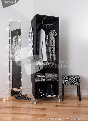 Image of Mirror and mobile wardrobe with clothing
