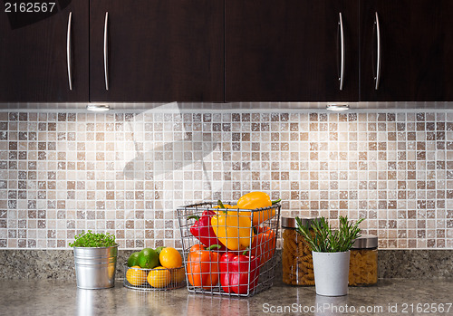 Image of Vegetables, fruits and herbs in a kitchen with cozy lighting