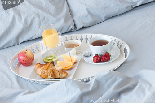 Image of Tray with healthy breakfast on a bed