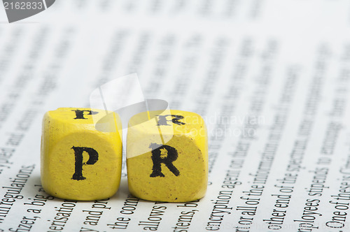 Image of Word PR.Wooden cubes on magazine