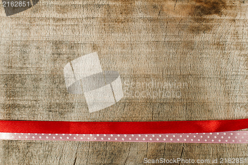 Image of Red ribbon for gift wrap on wooden background