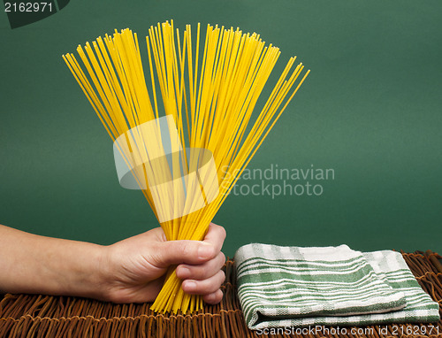 Image of Female hand holding spaghetti