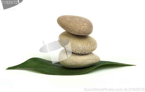 Image of Stacked stones on base of green leafs