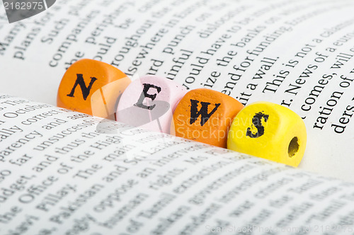 Image of Word news.Wooden cubes on magazine