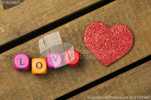 Image of Word love on multicolored wooden cubes on wooden background