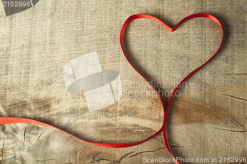 Image of Red ribbon heart on wooden background